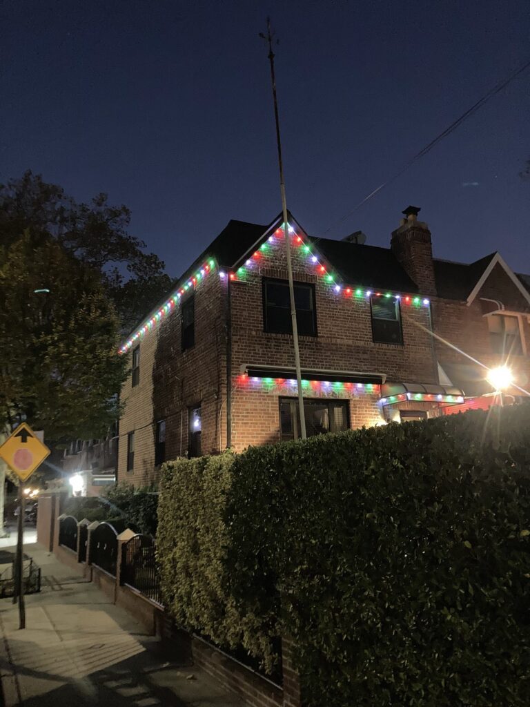 Brick house with a red and white permanent roofline on a corner lot