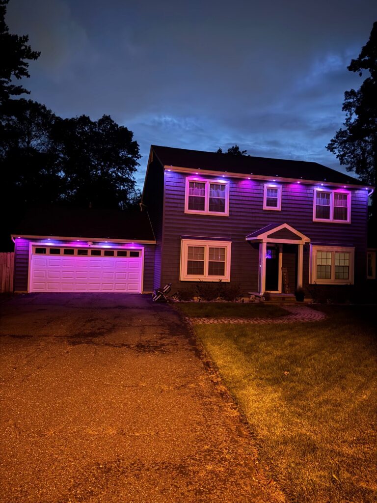 Colonial house with a purple permanent roofline at blue hour